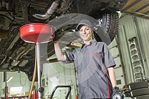 Mechanic woman working on car in his shop