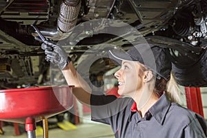 Mechanic woman working on car in his shop