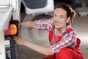 mechanic woman working on car in shop