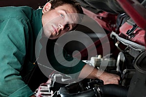 Mechanic at work fixing auto in auto service photo