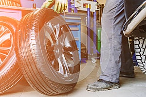 Mechanic worker changes wheels on car in garage of auto repair service shop