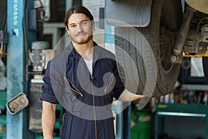 mechanic worker checking car replacing car wheel and tyre in auto repair shop store service. worker maintenance examining and