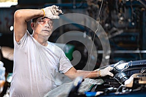 Mechanic worker in garage auto service tired stressed hardwork fatigue hot workplace wipe sweat