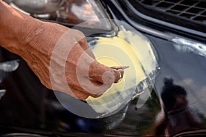 mechanic worker repairman fixing scratched on car body and preparing for painting.