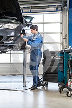 Mechanic, working on a car, checking the thickness of the brake