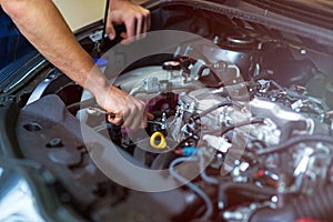 Mechanic working on car engine in auto repair shop photo