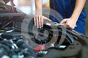 Mechanic working on car engine in auto repair shop