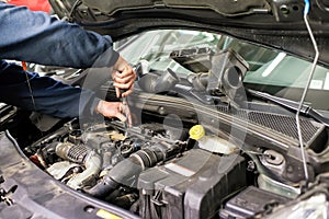 Mechanic working on a car engine doing repairs