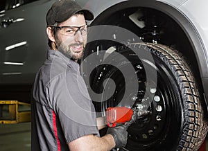 Mechanic working on car in his shop