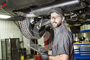 Mechanic working on car in his shop