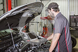 Mechanic working on car in his shop