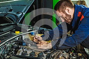 Mechanic working in car motor.