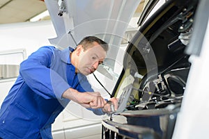 Mechanic working on front motor caravan