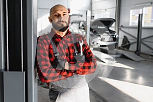 Mechanic working and holding wrench of service order for maintaining car at the repair shop