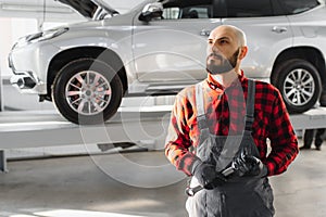 Mechanic working and holding wrench of service order for maintaining car at the repair shop