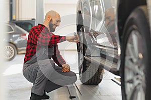 Mechanic working and holding wrench of service order for maintaining car at the repair shop