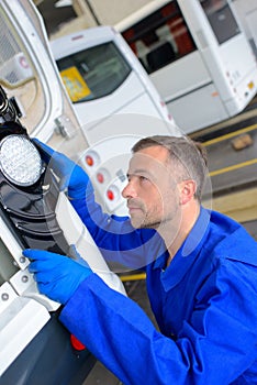 Mechanic working on rear light bus