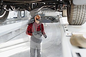 Mechanic working under car at the repair garage. Auto mechanic working in garage. Repair service