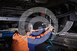 Mechanic Works on a Car in body shop