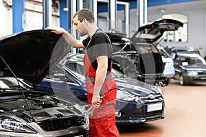 Mechanic in a workshop checks and inspects a vehicle for defects