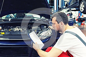 Mechanic in a workshop checks and inspects a vehicle for defects