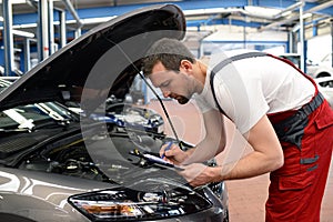 mechanic in a workshop checks and inspects a vehicle for defects