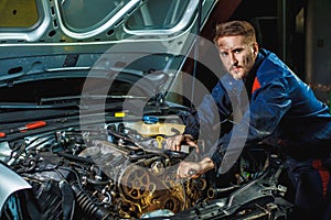 Mechanic with wrench working and repair car engine in car service centre