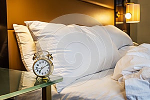 mechanical alarm clock is placed on the bedside table at home