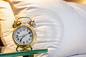 mechanical alarm clock is placed on the bedside table at home