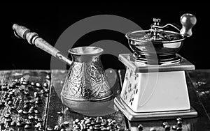 Mechanical coffee grinder, old copper cezve and coffee beans. Black and white.