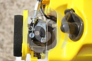 Mechanical components of a petrol brush cutter. Foam filter, starter or spark plug and choke lever in the carburetor of the