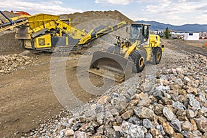 Mechanical conveyor belt and excavator to pulverize rock and stone and generate gravel photo