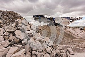 Mechanical conveyor belt to pulverize rock and stone and generate grave photo