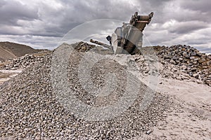 Mechanical conveyor belt to pulverize rock and stone and generate grave photo