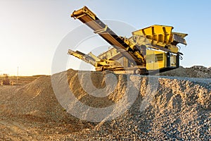Mechanical conveyor belt to pulverize rock and stone and generate gravel photo