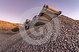 Mechanical conveyor belt to pulverize rock and stone and generate gravel photo