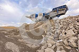 Mechanical conveyor belt to pulverize rock and stone and generate gravel photo