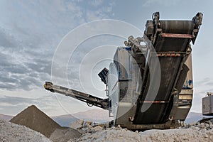 Mechanical conveyor belt to pulverize rock and stone and generate gravel photo