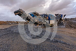 Mechanical conveyor belt to pulverize rock and stone and generate gravel photo