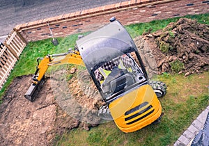 mechanical digger removing turf in front yard, garden for landscaping