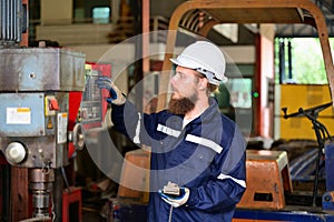 Mechanical engineer repairing engine machine at factory