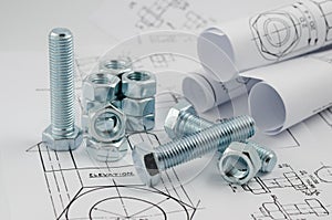 Mechanical Engineering Technology. Nuts and bolts on paper drawings photo