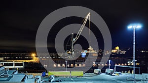 Mechanical hydraulic clamshell grabbers loading coal on ship at night.