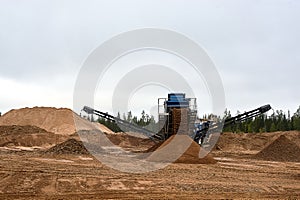 Mechanical machine for crushing stone with sand. Quarry for the extraction of crushed stone, sand and gravel