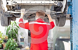 Mechanical man working in garage warehouse, Young mechanic fixing car in auto repair shop