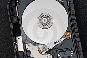 Mechanical parts of hard drive disk HDD inside a computer.