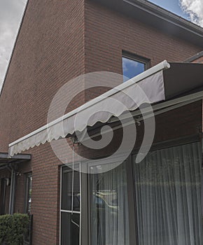 Mechanical retractable awning, tent built into the outer wall of the house