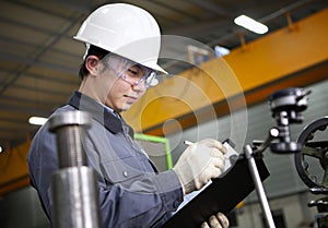 Mechanical technician writing on notepad