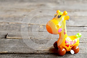 Mechanical wind up plastic giraffe toy. Pretty clockwork children toy on old wooden background. Fun children background