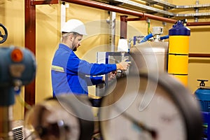 Mechanical worker adjusting pressure manometers on industrial equipment